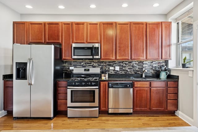 715 E 62nd St Unit 3, Chicago, IL 60637 - kitchen featuring stainless steel appliances, light wood-style floors, backsplash, dark stone counters, and recessed lighting