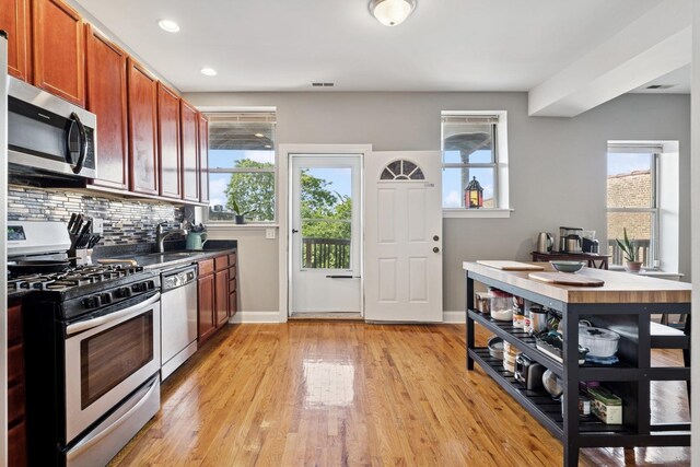 715 E 62nd St Unit 3, Chicago, IL 60637 - kitchen featuring appliances with stainless steel finishes, backsplash, light wood-type flooring, brown cabinetry, and recessed lighting