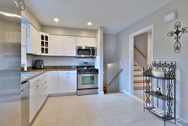 758 N Kenilworth Ave, Elmhurst, IL 60126 - kitchen featuring stainless steel appliances, dark stone counters, glass insert cabinets, white cabinetry, and recessed lighting
