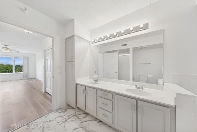 1 N Beacon Pl Unit 502, La Grange, IL 60525 - full bathroom featuring double vanity, a ceiling fan, a shower with shower door, a textured ceiling, and marble look tile flooring