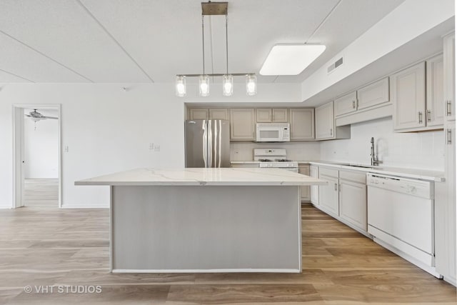 1 N Beacon Pl Unit 502, La Grange, IL 60525 - kitchen featuring white appliances, a kitchen island, light wood-type flooring, pendant lighting, and light stone counters