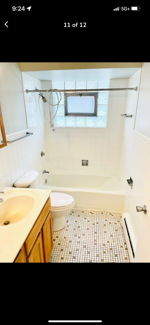 10425 S Hale Ave Unit 3A, Chicago, IL 60643 - full bath with tile walls, baseboard heating, vanity, tile patterned floors, and bathtub / shower combination