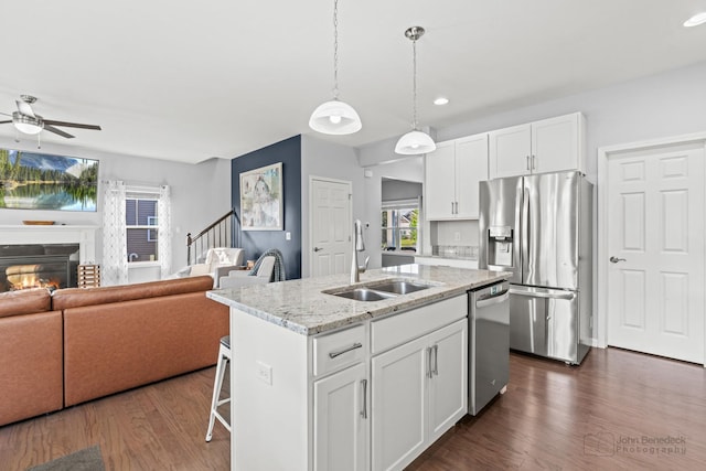 1402 Souders Ave, Elburn, IL 60119 - kitchen with appliances with stainless steel finishes, open floor plan, dark wood finished floors, a center island with sink, and white cabinets