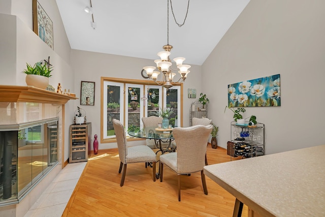 16813 Cardinal Dr, Orland Park, IL 60467 - dining room with wine cooler, a chandelier, light wood finished floors, track lighting, and high vaulted ceiling