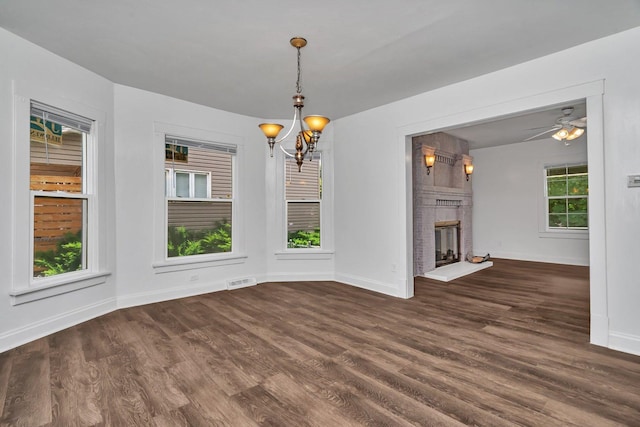 1057 W Park Front St, Joliet, IL 60436 - unfurnished dining area featuring a chandelier, a fireplace, wood finished floors, and ceiling fan