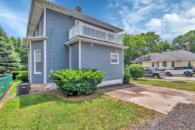 1057 W Park Front St, Joliet, IL 60436 - view of property exterior featuring a balcony, a yard, and a chimney
