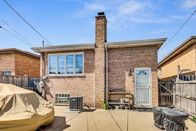 11531 S S Ave J, Chicago, IL 60617 - rear view of property featuring brick siding, a patio area, and a chimney