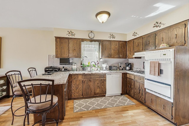11531 S S Ave J, Chicago, IL 60617 - kitchen featuring white appliances, a warming drawer, a peninsula, tasteful backsplash, and light wood-style floors