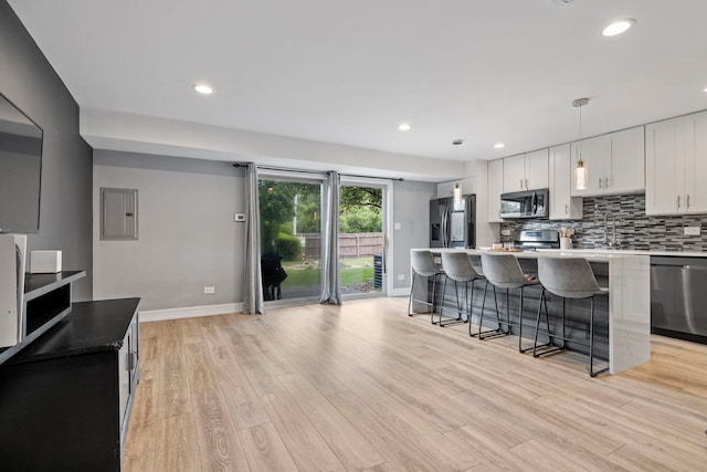 7 Cour Versaille, Palos Hills, IL 60465 - kitchen featuring appliances with stainless steel finishes, electric panel, a breakfast bar area, light wood-type flooring, and white cabinets