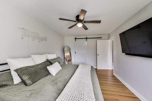 920 N Lakeside Dr Unit 1D, Vernon Hills, IL 60061 - bedroom featuring a barn door, wood finished floors, and a ceiling fan