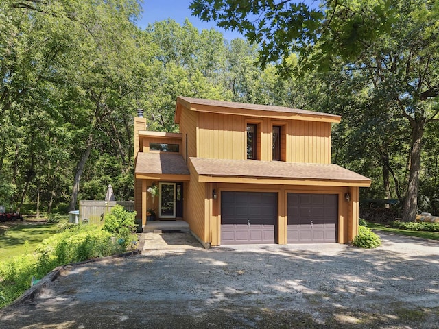 45W984 Mcdonald Rd, Hampshire, IL 60140 - view of front facade featuring a chimney, a garage, a shingled roof, and driveway