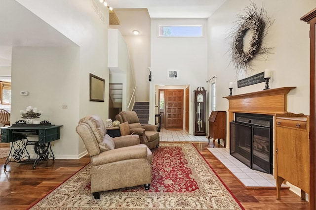 45W984 Mcdonald Rd, Hampshire, IL 60140 - living area with light wood-style flooring, stairway, a tiled fireplace, and a high ceiling