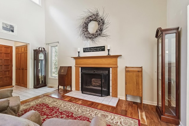 45W984 Mcdonald Rd, Hampshire, IL 60140 - living room featuring wood finished floors, a high ceiling, and a tile fireplace