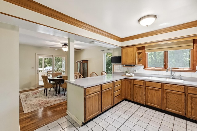 45W984 Mcdonald Rd, Hampshire, IL 60140 - kitchen with brown cabinets, decorative backsplash, a peninsula, healthy amount of natural light, and crown molding