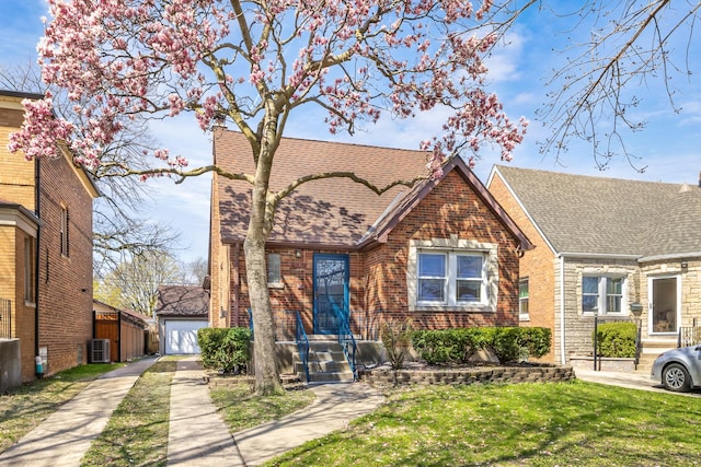 5632 S Natoma Ave, Chicago, IL 60638 - view of front of house featuring a shingled roof, brick siding, a front lawn, and a detached garage
