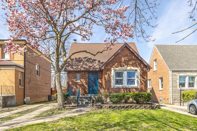5632 S Natoma Ave, Chicago, IL 60638 - view of front of home featuring brick siding, a chimney, a front lawn, and roof with shingles