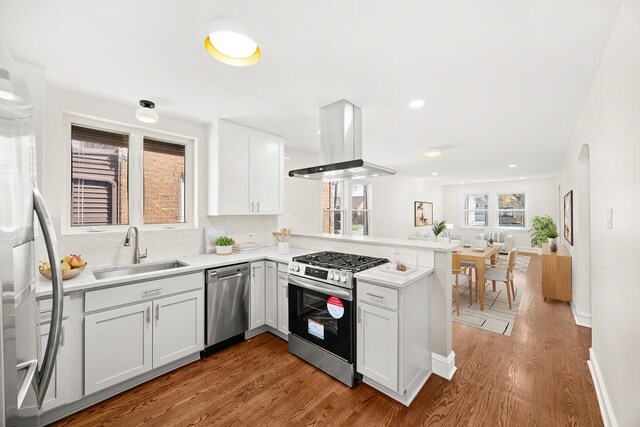 5632 S Natoma Ave, Chicago, IL 60638 - kitchen with stainless steel appliances, island range hood, a peninsula, wood finished floors, and recessed lighting