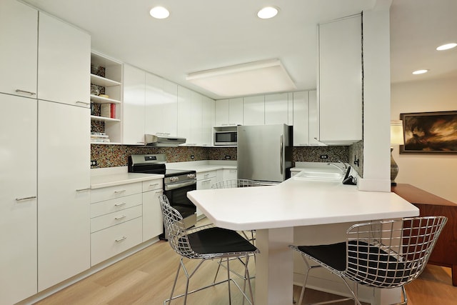 3030 Pheasant Creek Dr Unit 102, Northbrook, IL 60062 - kitchen with stainless steel appliances, under cabinet range hood, a peninsula, light wood-style floors, and recessed lighting
