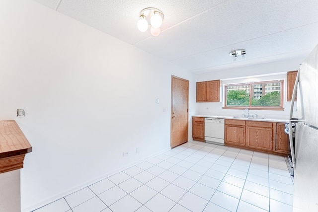 8710 W Evelyn Ln Unit 201, Chicago, IL 60656 - kitchen with white dishwasher, light countertops, brown cabinetry, stove, and a textured ceiling