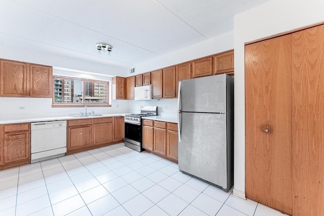 8710 W Evelyn Ln Unit 201, Chicago, IL 60656 - kitchen with stainless steel appliances, light countertops, brown cabinets, and light tile patterned floors