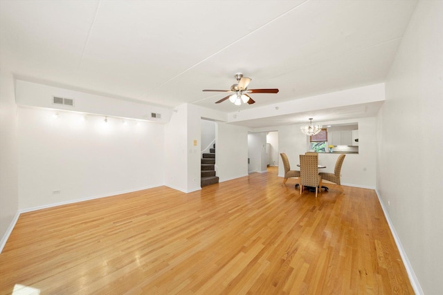 1036 Susan Collins Ln, Oak Park, IL 60302 - unfurnished dining area with stairs, light wood finished floors, ceiling fan, and a chandelier