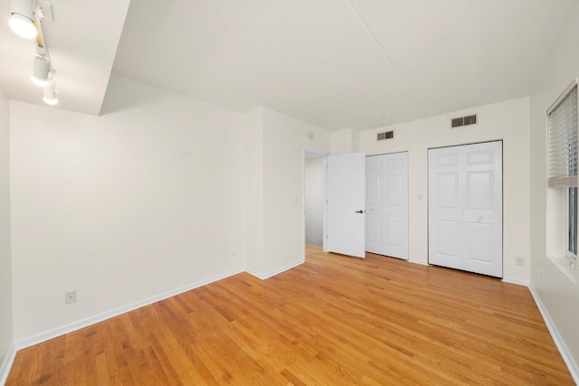 1036 Susan Collins Ln, Oak Park, IL 60302 - unfurnished bedroom with two closets and light wood-type flooring