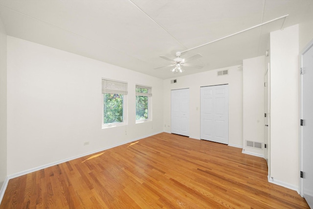 1036 Susan Collins Ln, Oak Park, IL 60302 - unfurnished bedroom with multiple closets, light wood-style flooring, and ceiling fan