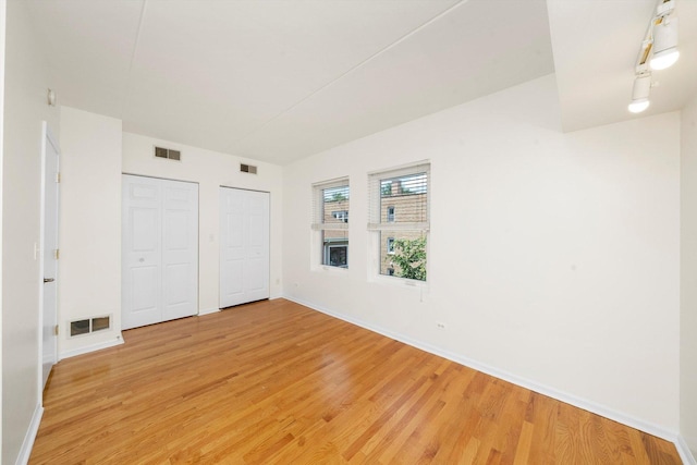 1036 Susan Collins Ln, Oak Park, IL 60302 - unfurnished bedroom featuring multiple closets and light wood-type flooring