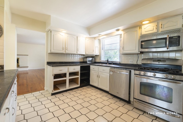 3S138 Park Blvd, Glen Ellyn, IL 60137 - kitchen featuring appliances with stainless steel finishes, dark countertops, decorative backsplash, open shelves, and white cabinets