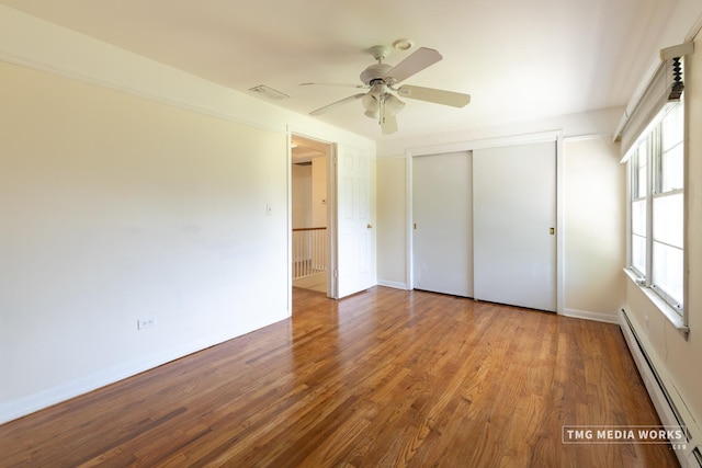 3S138 Park Blvd, Glen Ellyn, IL 60137 - unfurnished bedroom with baseboard heating, multiple windows, a closet, and wood finished floors