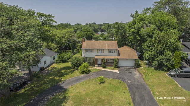 3S138 Park Blvd, Glen Ellyn, IL 60137 - view of front of house with driveway, an attached garage, a front lawn, and a chimney