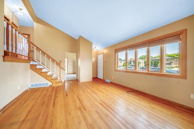 12236 S Hamlin Ave, Alsip, IL 60803 - unfurnished living room featuring wood finished floors, stairway, and vaulted ceiling