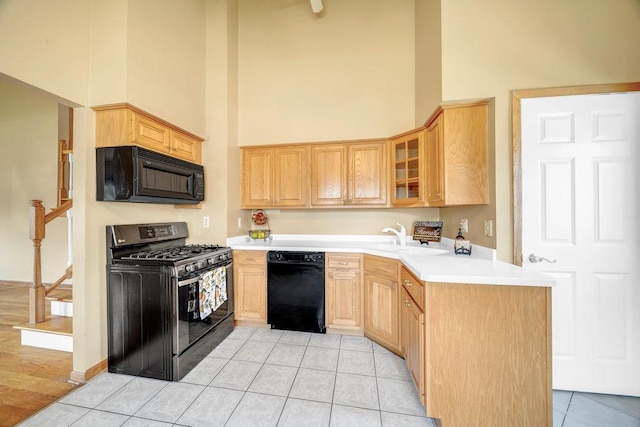 12236 S Hamlin Ave, Alsip, IL 60803 - kitchen featuring black appliances, a towering ceiling, light brown cabinets, light tile patterned floors, and glass insert cabinets