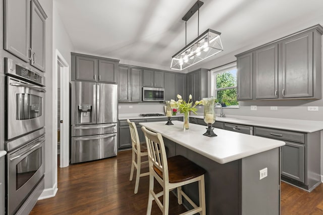 802 Barton Dr, Oswego, IL 60543 - kitchen with appliances with stainless steel finishes, gray cabinets, a chandelier, and dark wood-type flooring