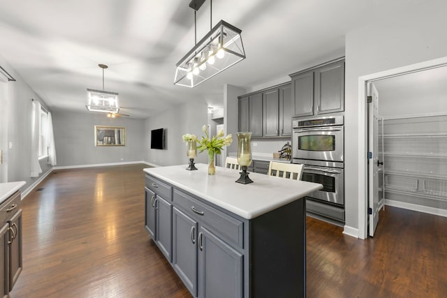 802 Barton Dr, Oswego, IL 60543 - kitchen with stainless steel double oven, dark wood-style floors, gray cabinets, and open floor plan