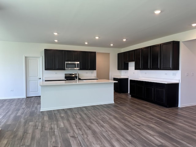 25805 W Springside St, Plainfield, IL 60586 - kitchen featuring appliances with stainless steel finishes, wood finished floors, a kitchen island with sink, light countertops, and recessed lighting