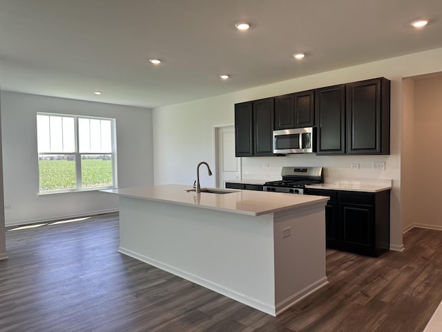 25805 W Springside St, Plainfield, IL 60586 - kitchen with appliances with stainless steel finishes, an island with sink, light countertops, dark wood finished floors, and dark cabinets