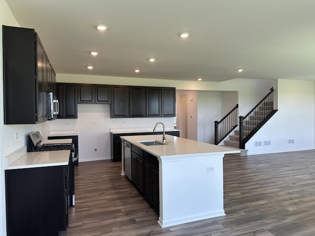 25805 W Springside St, Plainfield, IL 60586 - kitchen with black range with gas cooktop, dark wood-type flooring, an island with sink, light countertops, and dark cabinets