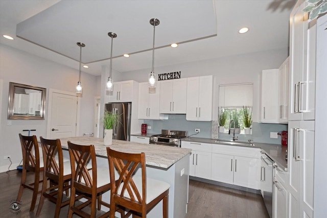 609 E 48th St, Chicago, IL 60615 - kitchen with stainless steel appliances, a center island, a breakfast bar area, white cabinetry, and recessed lighting