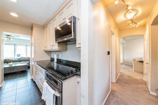 235 S Warrington Rd, Des Plaines, IL 60016 - kitchen with appliances with stainless steel finishes, a ceiling fan, dark stone countertops, arched walkways, and track lighting