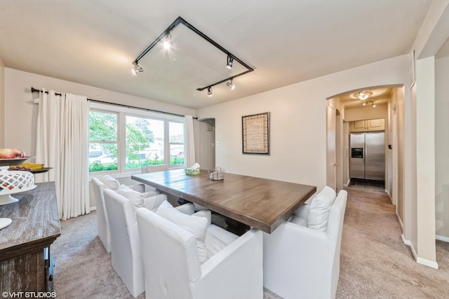235 S Warrington Rd, Des Plaines, IL 60016 - dining area featuring light carpet, arched walkways, and rail lighting