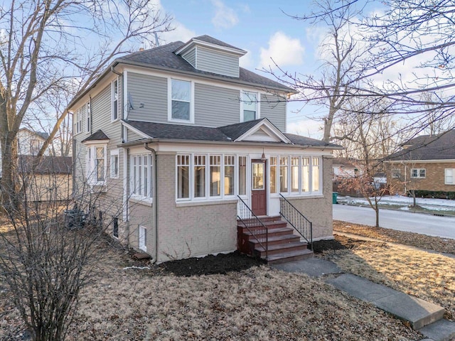 150 N Raynor Ave, Joliet, IL 60435 - american foursquare style home with brick siding, entry steps, and roof with shingles
