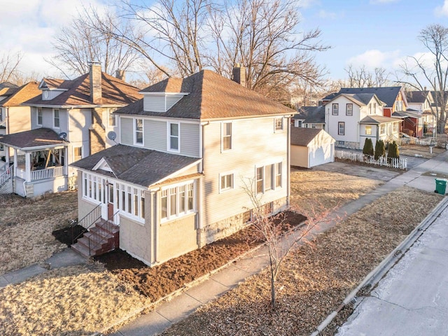 150 N Raynor Ave, Joliet, IL 60435 - view of home's exterior with a residential view, a chimney, entry steps, a shingled roof, and an outbuilding