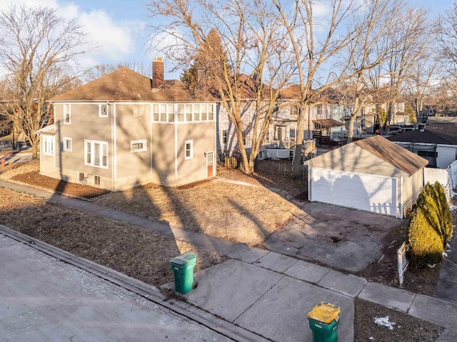 150 N Raynor Ave, Joliet, IL 60435 - view of front of house featuring a chimney, a detached garage, an outdoor structure, stucco siding, and a residential view