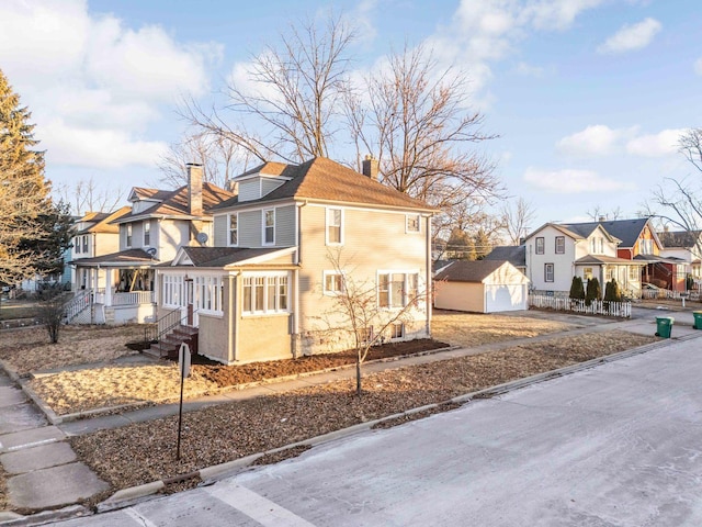150 N Raynor Ave, Joliet, IL 60435 - view of front of property with a chimney, a residential view, an outdoor structure, and driveway