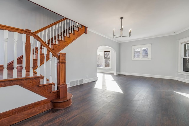 150 N Raynor Ave, Joliet, IL 60435 - unfurnished living room featuring arched walkways, a chandelier, ornamental molding, wood finished floors, and stairway