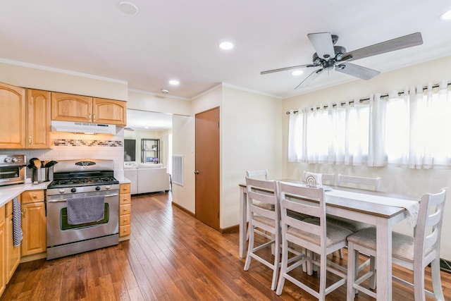 15246 S Millard Ave S, Midlothian, IL 60445 - kitchen featuring stainless steel gas stove, under cabinet range hood, tasteful backsplash, dark wood-style flooring, and light countertops