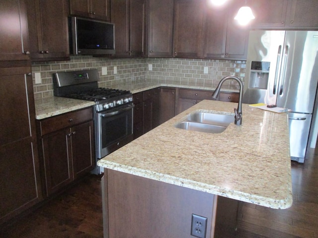 201 Cattail Ave, Savoy, IL 61874 - kitchen featuring stainless steel appliances, backsplash, light stone counters, and a center island with sink