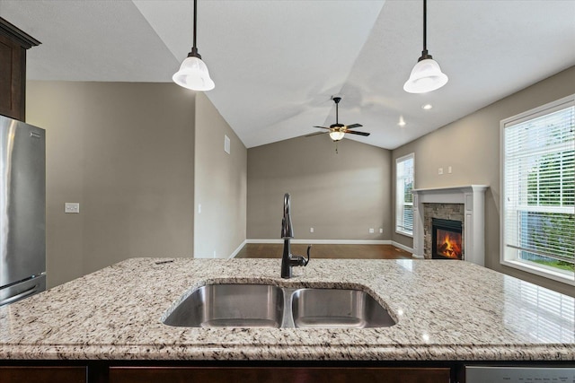 201 Cattail Ave, Savoy, IL 61874 - kitchen featuring dark brown cabinetry, freestanding refrigerator, pendant lighting, a stone fireplace, and lofted ceiling