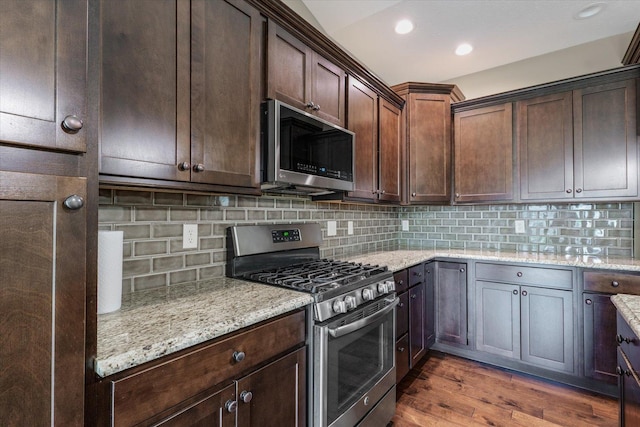 201 Cattail Ave, Savoy, IL 61874 - kitchen with stainless steel appliances, light stone counters, wood finished floors, decorative backsplash, and dark brown cabinets